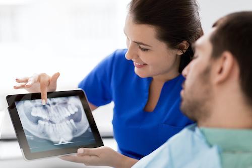 A dentist showing a patient his dental x-rays