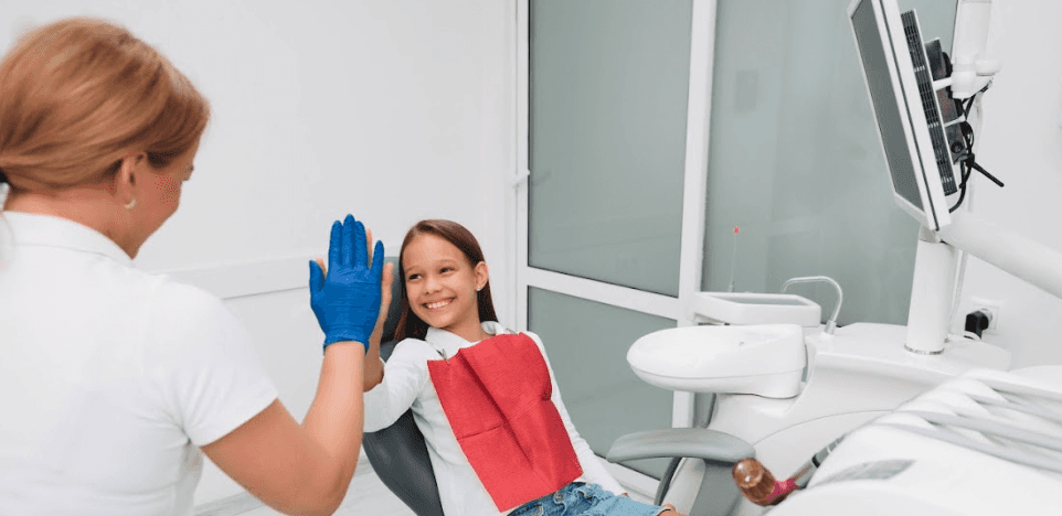 A girl high-fiving her dentist