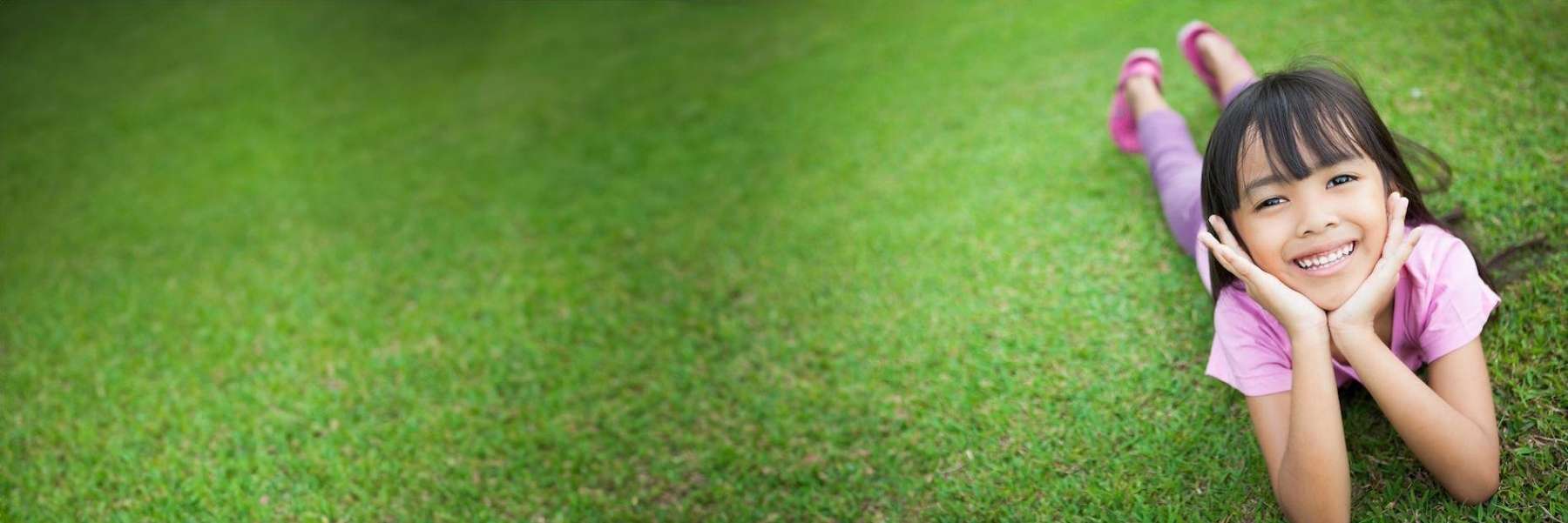 A smiling girl laying in the grass