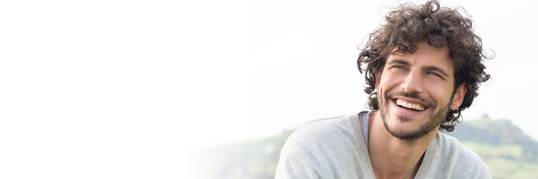 Man smiling outside near Norfolk dentist office