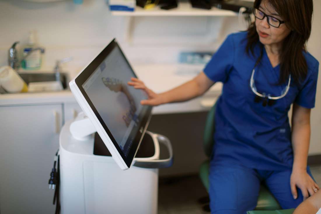 A dentist showing a patient their dental cone beam images in Norfolk MA