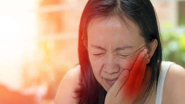 A woman with a toothache holding her jaw
