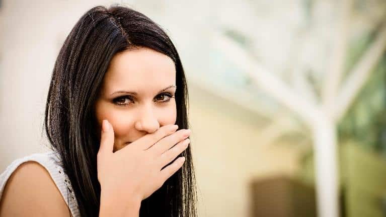 Woman covering her smile with her hand