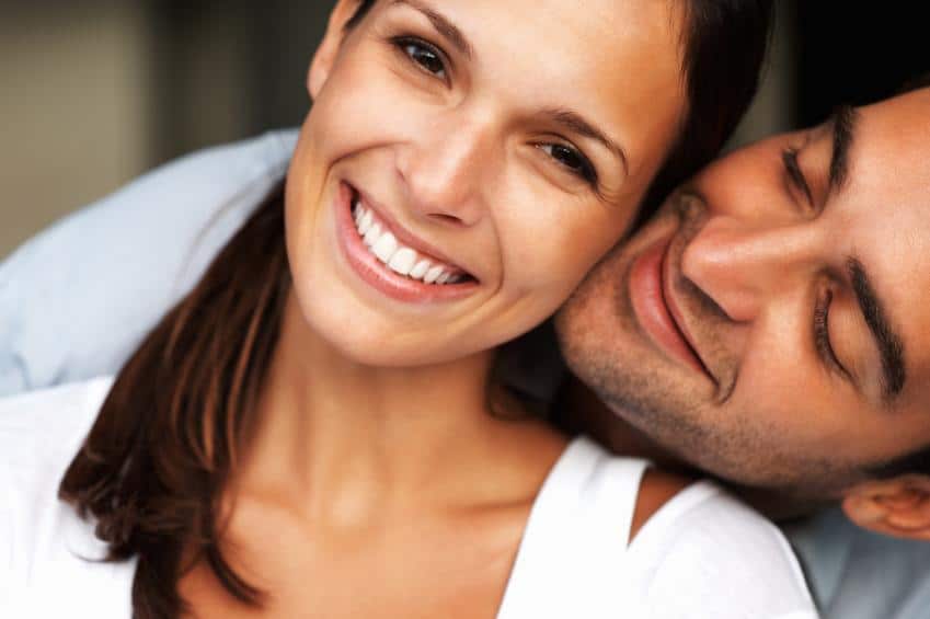 Close up of smiling couple wearing porcelain veneers in Norfolk